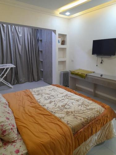 un grande letto in una camera con TV di عمارات ميلسا سيتى ستارز a Banī Ghālib