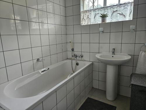 Un baño blanco con bañera y lavabo. en 48 Cintsa Bay, en Cintsa West