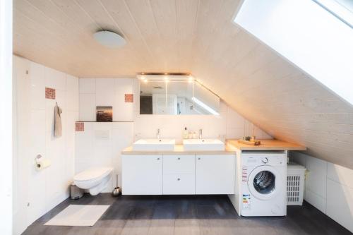 ein Badezimmer mit Waschbecken und Waschmaschine in der Unterkunft Ferienwohnung Firstblick in Egg