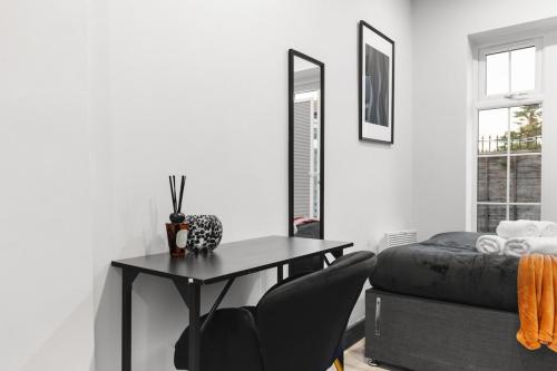 a bedroom with a desk and a bed and a table at Stylish Studio and Parking Fast access Central London in Perivale