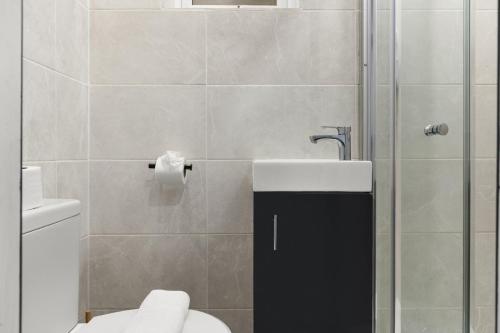a bathroom with a shower and a toilet and a sink at Stylish Studio and Parking Fast access Central London in Perivale