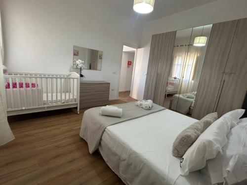 een slaapkamer met een groot bed en een babybedje bij Casalileo in San Giovanni Suèrgiu