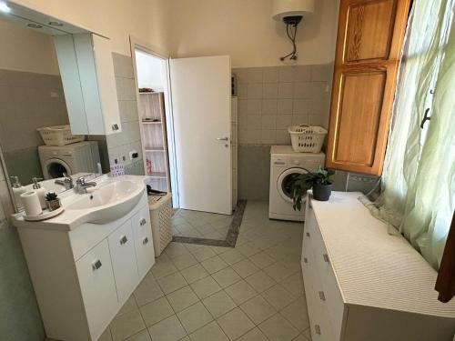 een badkamer met wastafel en wasmachine bij Casalileo in San Giovanni Suèrgiu