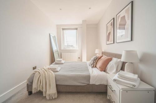 a white bedroom with a bed and a window at Fabulous Central Eastleigh 1 Bedroom Apartment in Eastleigh