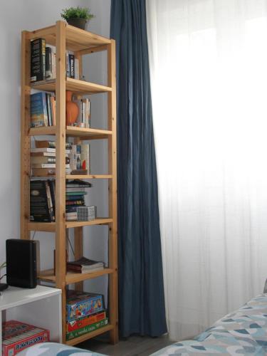 a book shelf with books on it next to a bed at Peixe Agulha in Tavira