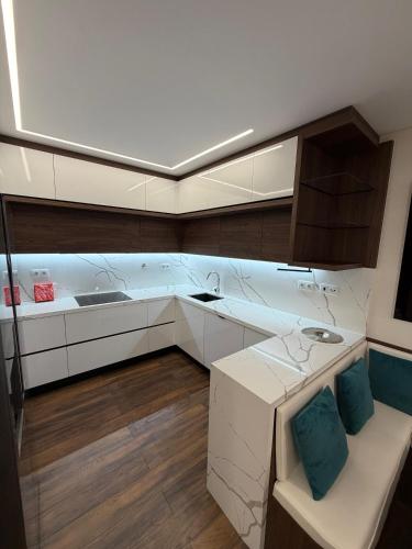a kitchen with white cabinets and blue pillows at Riverside Residence in Póvoa de Santa Iria