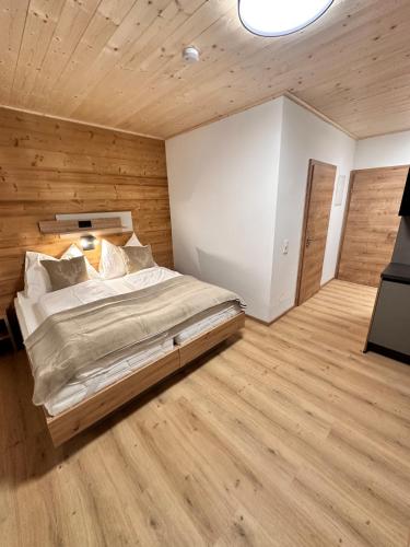 een slaapkamer met een groot bed en houten wanden bij Alpin Studio Schladming 101 in Schladming