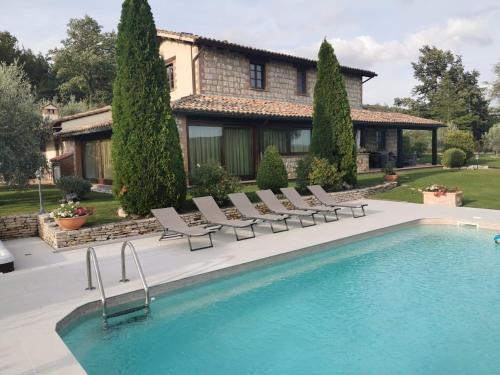 Il Casale del Conte في Fratta Todina: منزل به حوض سباحة أمام المنزل