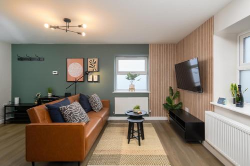 a living room with a couch and a tv at CityPad2 Stylish City Centre 2BR Apartment with Free Parking & WIFI in Cardiff