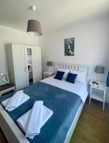 a bedroom with a large bed with blue and white sheets at Hrebet House Borovets in Borovets