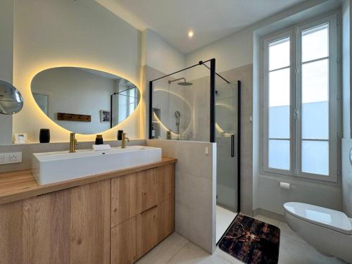 Le Cerf - Rambouillet city center في رامبوييه: حمام مزود بحوض ومِرآة