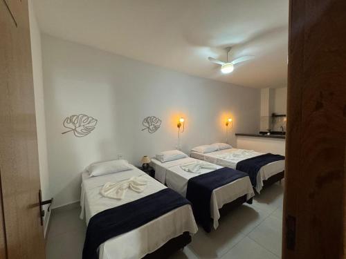 een kamer met 3 bedden en een keuken bij Hey Mar Suites in Arraial do Cabo