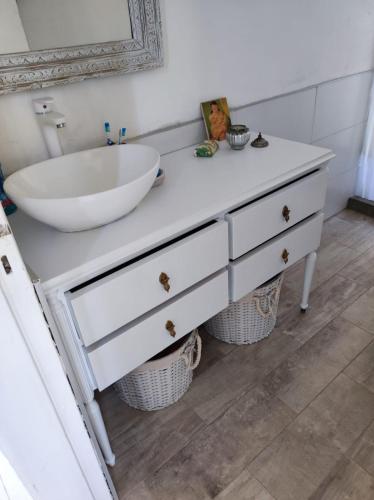 een badkamer met een witte wastafel en een bad bij La Preta, casa de campo in San Clemente