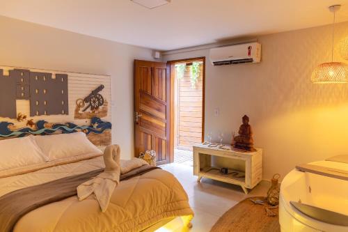 a bedroom with a bed and a table and a window at Pousada e Chalé Lote 22 in Ilha do Mel