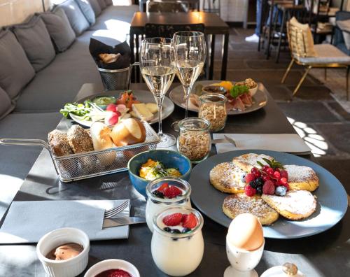 una mesa con platos de comida y copas de vino en Alter Schlachthof, en Bresanona