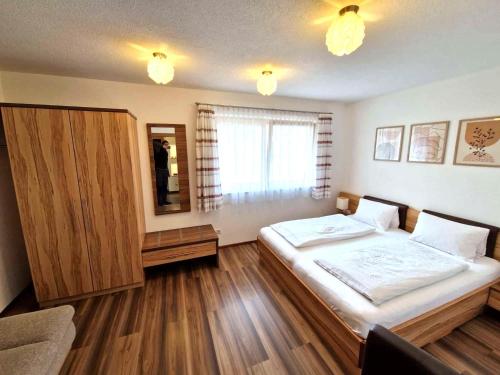 Un dormitorio con una cama grande y un espejo. en Schiestl, en Ramsau im Zillertal