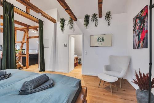 a bedroom with a bed and a chair at Novita apartment 2 - central - balcony - mountain views in Bad Harzburg