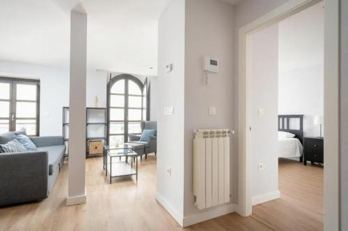 ein weißes Wohnzimmer mit einem Sofa und einem Bett in der Unterkunft AVG Numa Guilhou 4 in Gijón