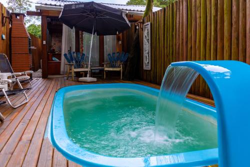 a pool with a water fountain on a wooden deck at Pousada e Chalé Lote 22 in Ilha do Mel