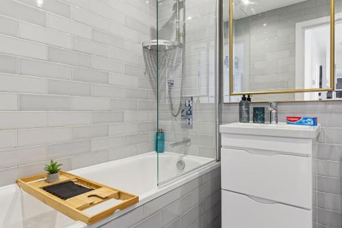 a bathroom with a bathtub with a cutting board on it at Luxury Two Bedroom Living - Central London & Westminster in London