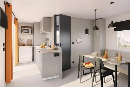 Una cocina y un comedor con mesa y sillas. en Camping 4 étoiles - ccbcagb, en Le Gillieux