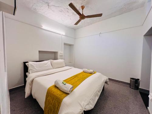 a bedroom with a bed with a ceiling fan at Hostel Dara Jaisalmer in Jaisalmer