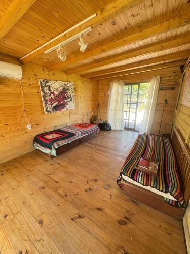 a large room with two beds in a log cabin at Amanda Relax and nature beautiful beach in Playa Hermosa
