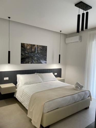 a bedroom with a large bed and a painting on the wall at B&B Cariddi Rooms in Caltanissetta