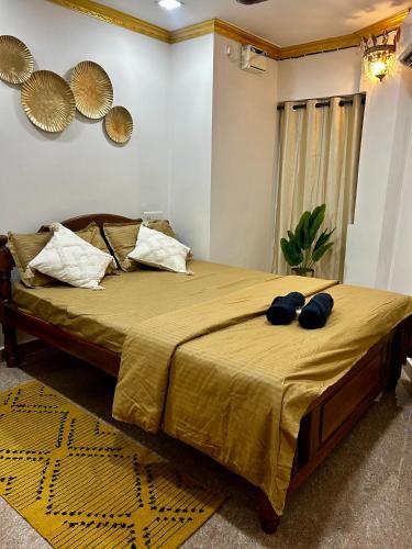 uma cama com duas almofadas azuis em cima em Casa Amore em Benaulim