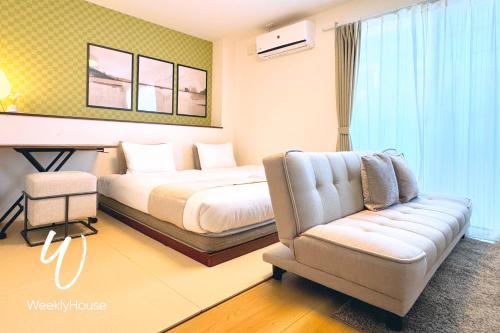 una habitación de hotel con una cama y un sofá en WeeklyHouse Schildkrote, en Otsu