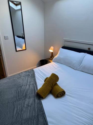 a brown towel laying on a white bed at Cockermouth Cottage - Lakes - Parking in Cockermouth