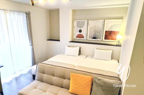 Un dormitorio con una cama grande y un sofá. en WeeklyHouse Schildkrote, en Otsu