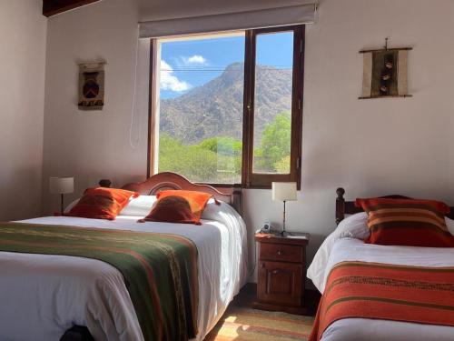 una camera da letto con due letti e una grande finestra di El Descanso Cafayate a Cafayate
