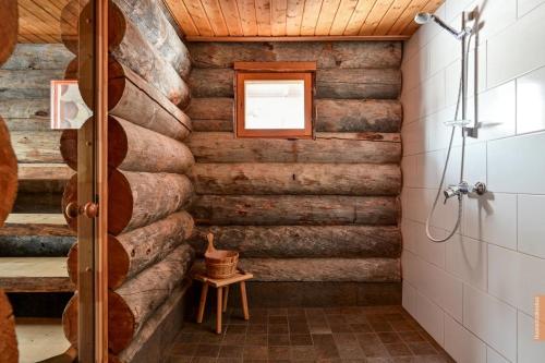 a bathroom with wooden walls and a shower stall at Käenpesän Aihki in Syöte