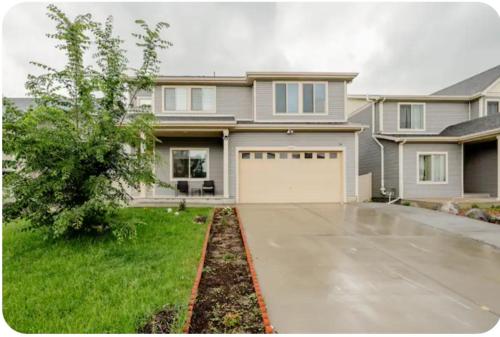 a large house with a driveway and a garage at Sweet stay near Denver airport in DEN