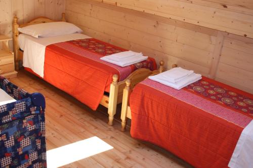 two beds in a room with wooden walls at Albergo Diffuso Faller in Faller