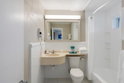 un bagno con lavandino, WC e specchio di Atlantis Lodge a Pine Knoll Shores