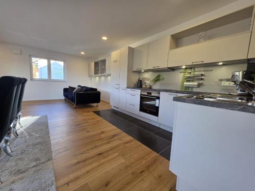 a kitchen with white cabinets and a black counter top at Malerischer Panoramablick Worgberg in Ingelfingen
