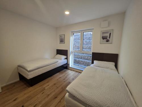 two beds in a room with a window at Malerischer Panoramablick Worgberg in Ingelfingen