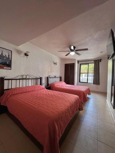 sypialnia z dwoma łóżkami i wentylatorem sufitowym w obiekcie Hotel Uke Inn Terán w mieście Tuxtla Gutiérrez