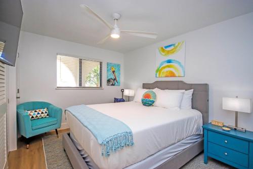 a bedroom with a large bed and a blue chair at 3rd Story Sanibel Condo With Coastline Views 3C3 in Sanibel