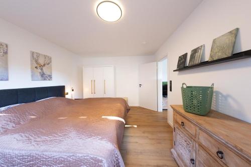 a bedroom with a large bed and a wooden dresser at kleines KunzGlück in Waldbronn
