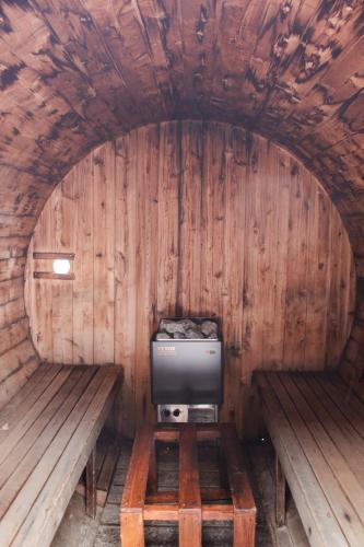 a small room with two benches and a tv in it at Refuge du Fjord in Saguenay