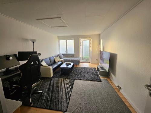 a living room with a couch and a chair at Cozy One Room Apartment in Roskilde
