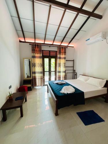 a bedroom with a large bed and a table at Ivy Villa - Tangalle in Tangalle