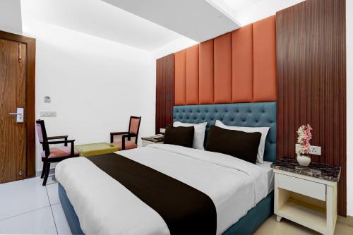 una camera da letto con un letto grande con testiera arancione e blu di Hotel O elvilla a Nuova Delhi