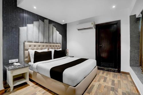 una camera da letto con un grande letto con una coperta bianca e nera di Hotel O elvilla a Nuova Delhi