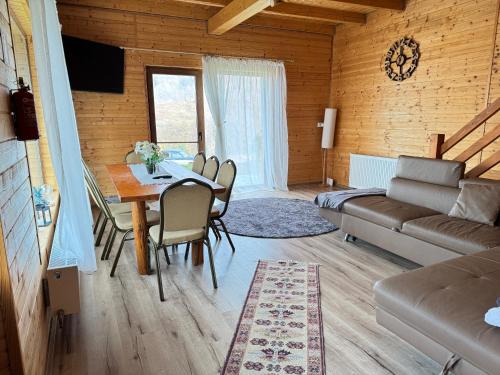 una sala de estar con una mesa y un sofá en Cabana Izvorul Rece Maramureş, en Baia-Sprie
