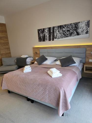ein Schlafzimmer mit einem großen Bett mit zwei Handtüchern darauf in der Unterkunft Aparthotel Apartamenty Czarna Góra 307 in Heudorf