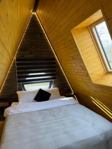 sypialnia z łóżkiem w drewnianym pokoju w obiekcie Лісовий Трикутник w mieście Mikuliczyn